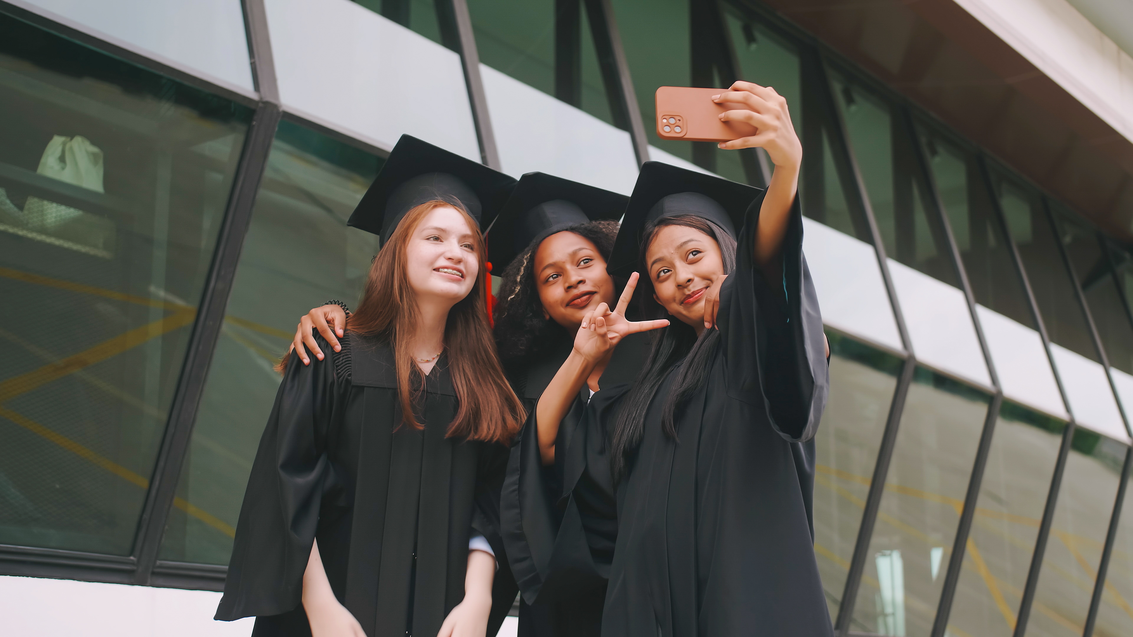 Group of friends having fun celebrating their graduation by taking pictures together.